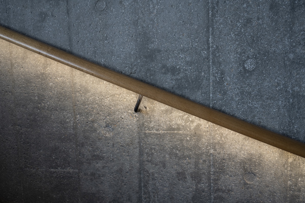 A concealed linear light follows the edge of a sculptural handrail